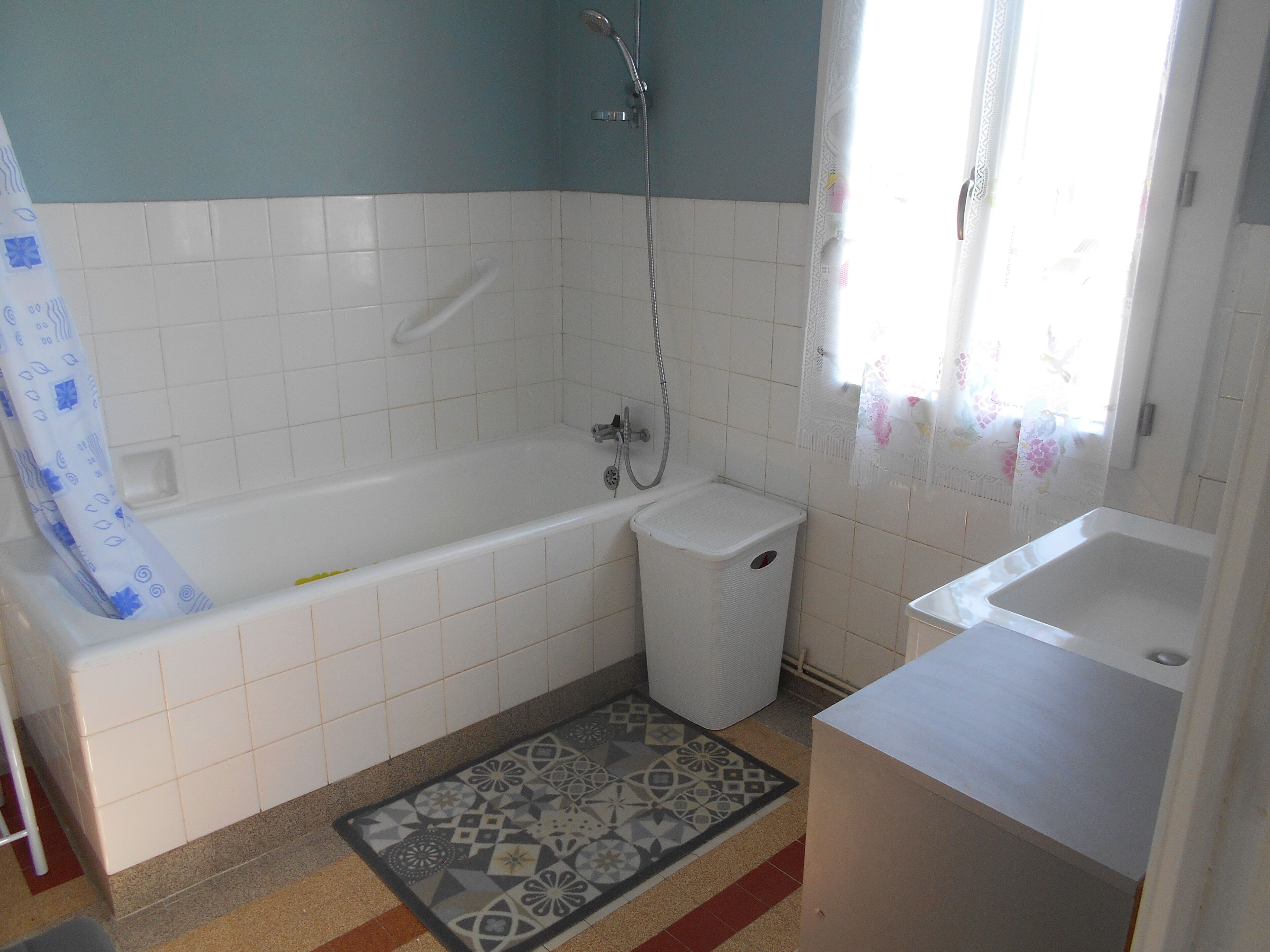 Een badkamer met een bad, een douche, een toilet en een wastafel.
