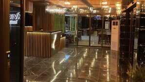 Rebedor d'hotel amb taulell de recepció, escala i senyalització de sortida.