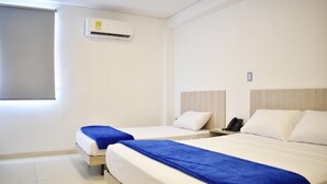 Ein Hotelzimmer mit zwei Betten, einem Fenster, einer Klimaanlage und einem Nachttischtelefon.