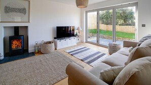 A modern living room with a fireplace, a television, and a sofa. - Elmwood (Port Isaac)