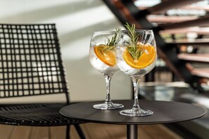 Two glasses of a beverage with an orange slice and a sprig of rosemary on a round table. - Hotel Schillerhof Weimar (Weimar)