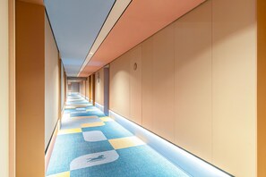 A long, narrow hallway with a patterned carpet and beige walls. - Hanting Hotel (Xi'an)