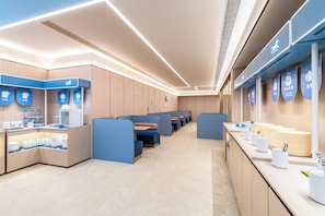 A modern restaurant with booths, a counter, and a menu display. - Hanting Hotel (Xi'an)