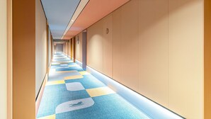 A long, narrow hallway with a patterned carpet and beige walls. - Hanting Hotel (Xi'an)