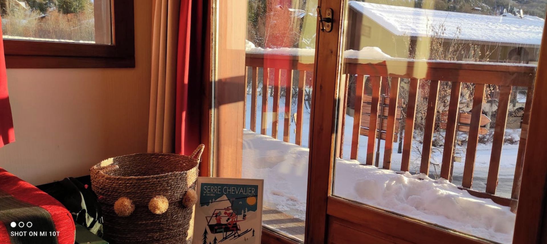 A wooden door with a view of a snowy deck outside.
