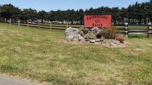 A sign for Cornerstone Ranch in a grassy field with a wooden fence and trees in the background. - Cornerstone Ranch experience minutes to the beach and Rogue River (Gold Beach)