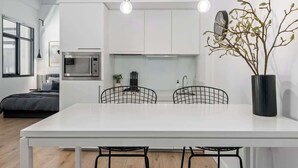 Een moderne keuken met witte kasten, een centraal eiland met stoelen en hanglampen.