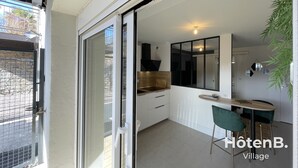 A modern kitchen with a sliding glass door leading to a balcony. - Town Hall Studio - Hyper-center Limoges (Limoges)