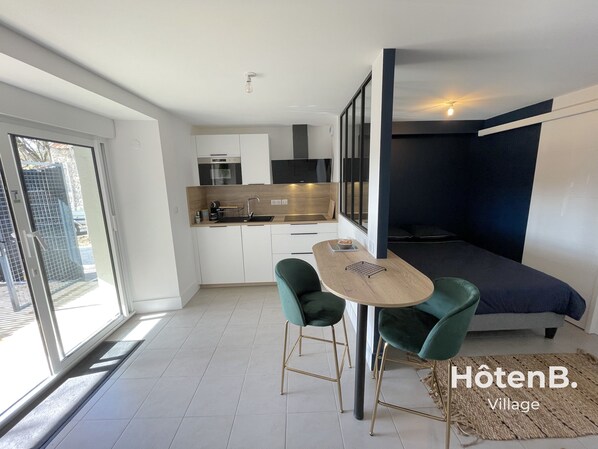 A modern kitchen with a dining area, a sofa bed, and a small table with chairs. - Town Hall Studio - Hyper-center Limoges (Limoges)