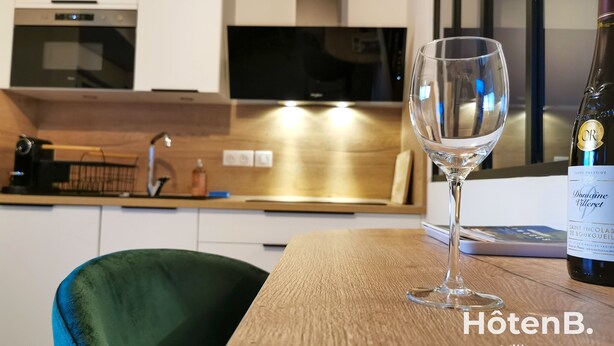 A modern kitchen with a wine glass and bottle on the table. - Town Hall Studio - Hyper-center Limoges (Limoges)