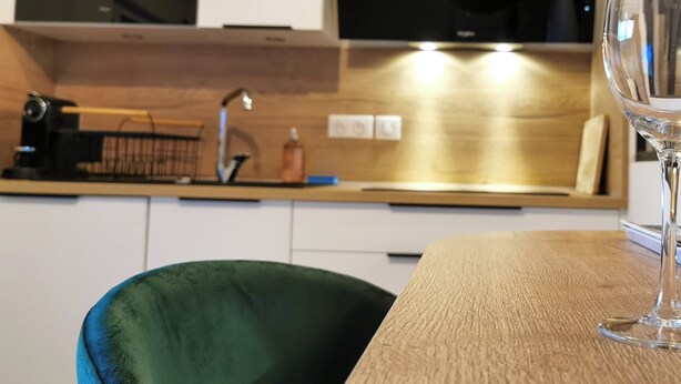 A modern kitchen with a wine glass and bottle on the table. - Town Hall Studio - Hyper-center Limoges (Limoges)