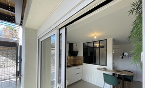 A modern kitchen with a sliding glass door leading to a balcony. - Town Hall Studio - Hyper-center Limoges (Limoges)