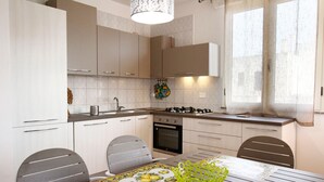 A modern kitchen with white cabinets, a gas stove, and a dining area with a table and chairs.