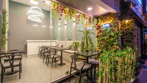A modern hotel lobby with a sofa, tables, and chairs. There is a neon sign that reads "Best Hotel." - Best Hotel Kadikoy (Istanbul)