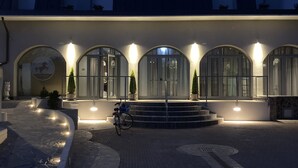 Un edificio con ventanas de arco y una escalera que lleva a la entrada.