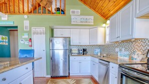 A kitchen with white cabinets, a stainless steel refrigerator, a microwave, and an oven.