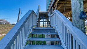 A wooden staircase leading to a building with a green roof.