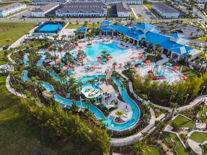 A resort with a large central pool, multiple water slides, and a variety of sun loungers and umbrellas. - Themed Pool Home w/ Resort Amenities Near Disney (Davenport)