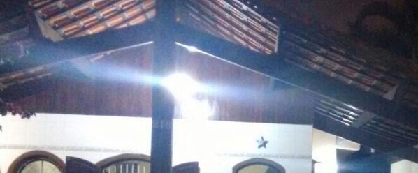 A room with a high ceiling, wooden beams, and a star decoration on the wall.