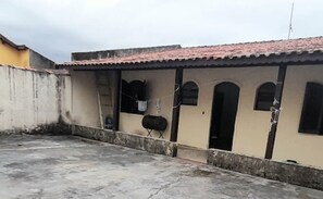 A building with a tiled roof, arched windows, and a concrete floor.