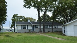 A two-story house with a front yard, a driveway, and a small shed. - Make memories in this cozy water front house on Eagle Mountain Lake. (Azle)