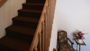 A staircase with wooden railings and carpeted steps leading to a landing. - Shepody Bay Inn (Shepody)