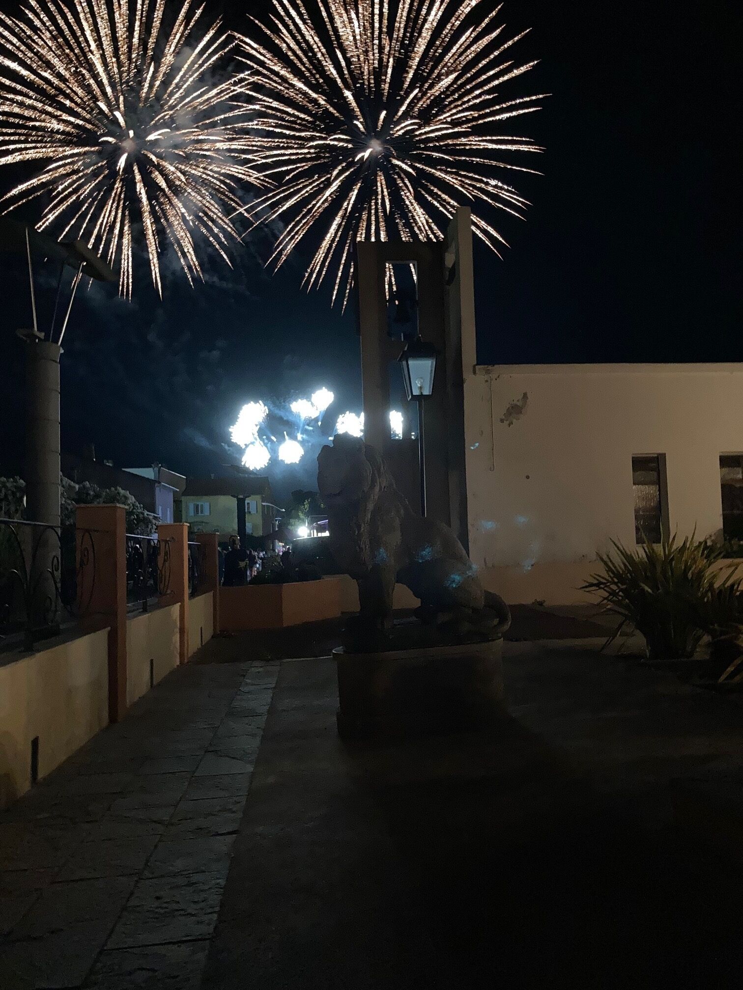 Nachtszene mit Feuerwerk, einem Weg und einem Gebäude mit einer Lampe.