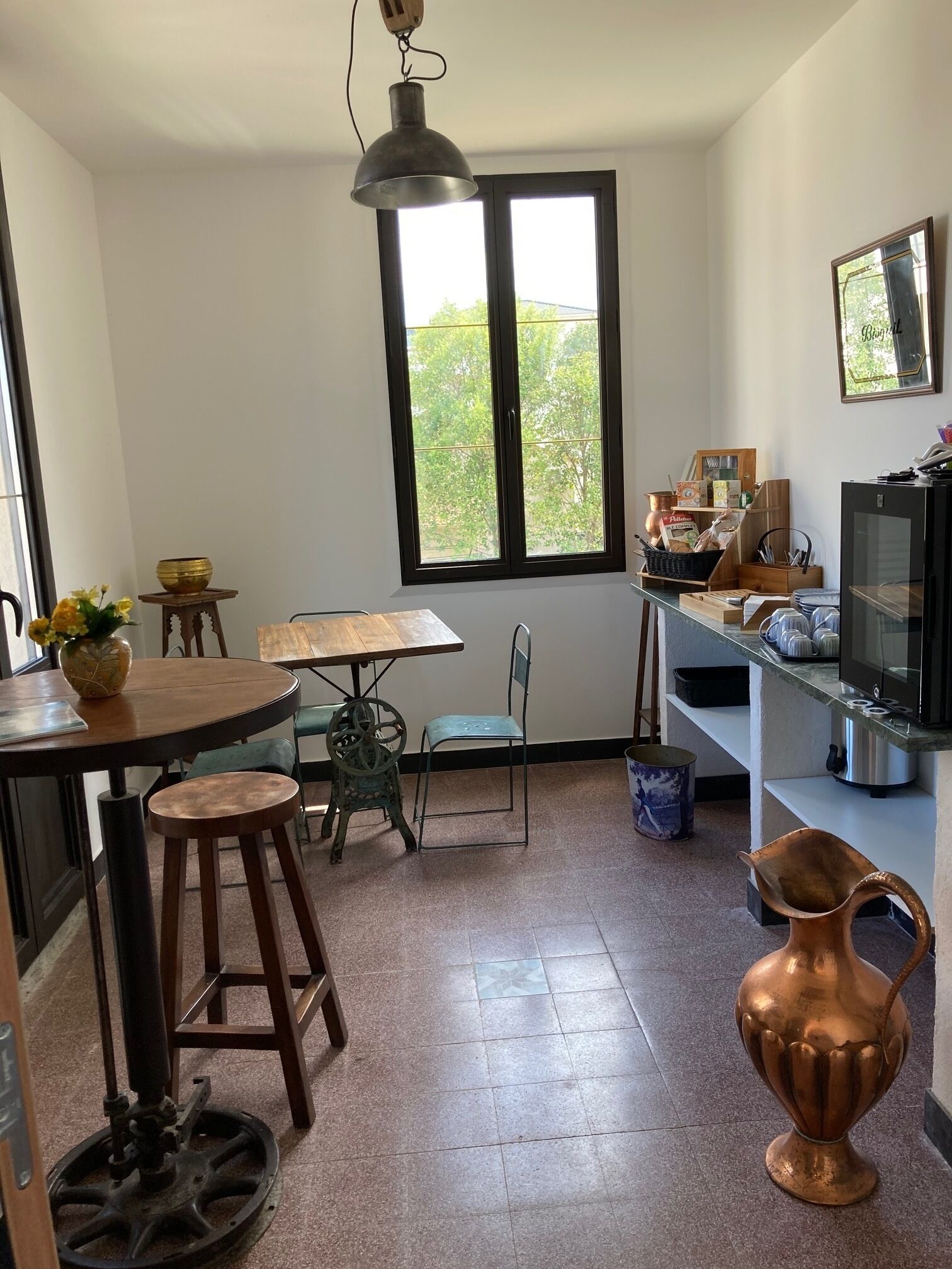 Una cocina compacta con comedor, un ventanal grande y un televisor.