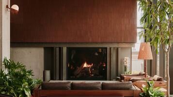 Una sala de estar acogedora con chimenea, muebles de madera y plantas en macetas.
