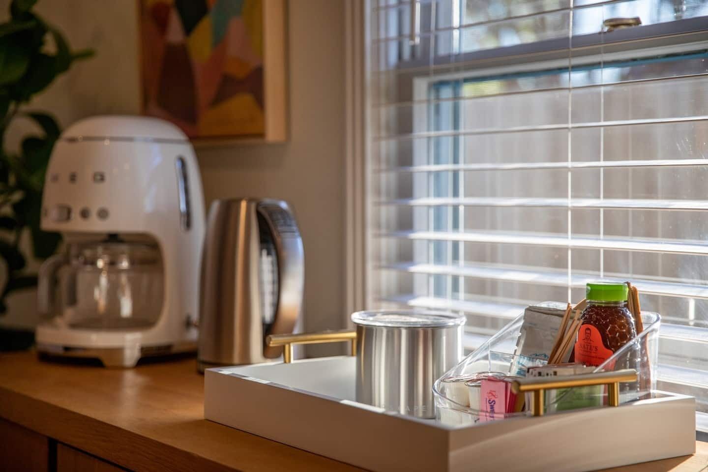 A kitchen counter with a coffee maker, toaster, and a glass jar with a label.
