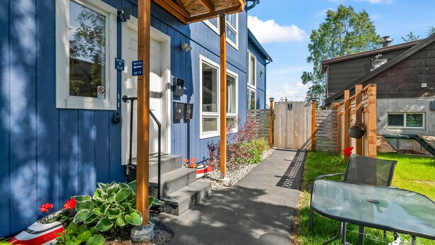 A blue house with a porch, a mailbox, and a small garden. - The Alpenglow Loft - 1 Bed/1Bath- Radiant Charmer (Anchorage)