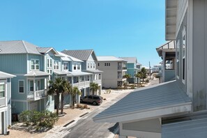 A row of coastal houses with a clear sky, a parked car, and a palm tree. - 🌊Dip Your Toes: Pet-Friendly Cottage w/ Intracoastal Access and Community Pool (Navarre)