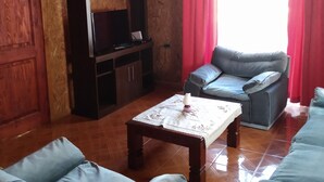 A living room with a sofa, a TV stand, and a table.