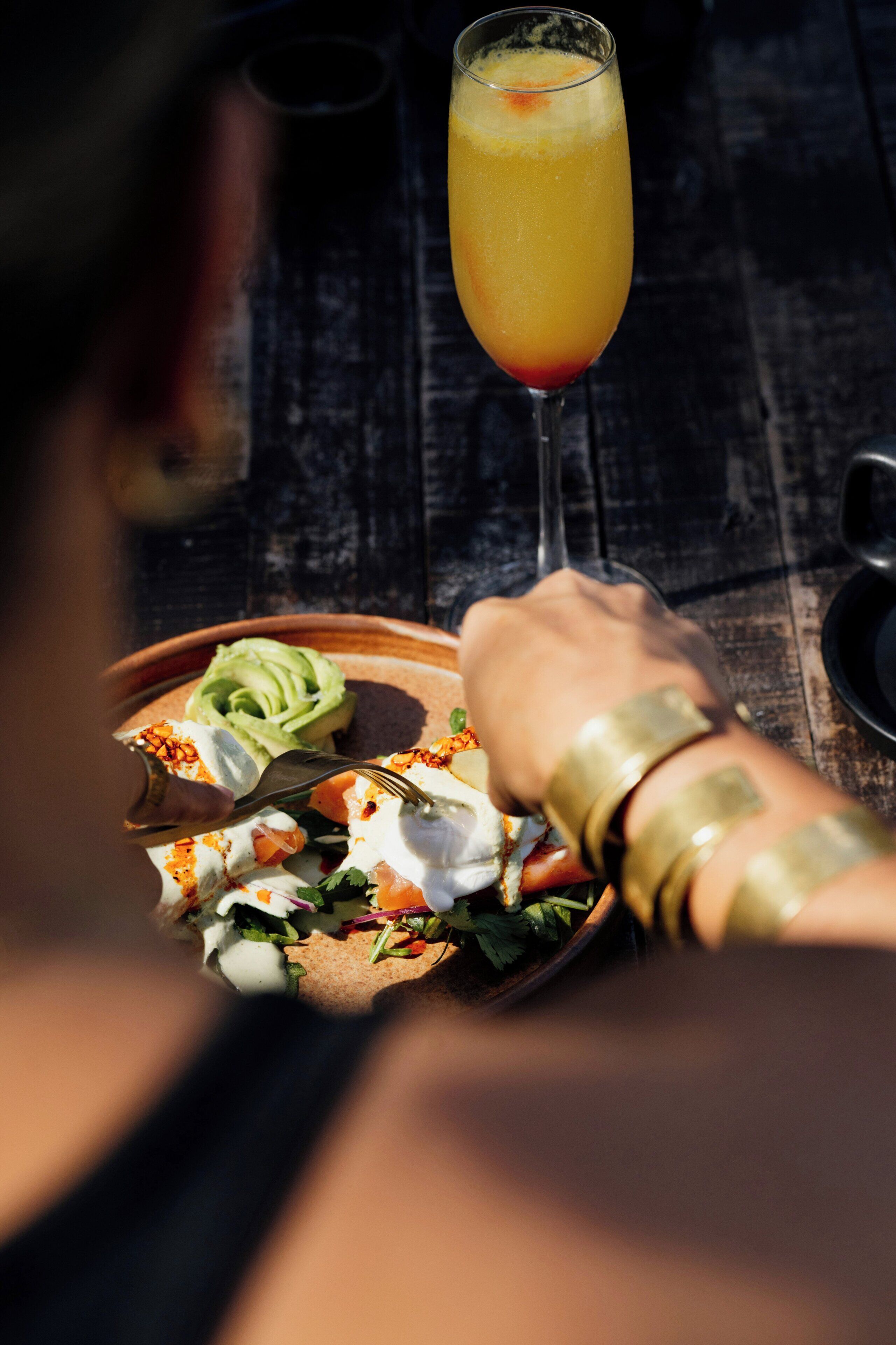 Una mesa de comedor con un plato de comida y un vaso de jugo de naranja.