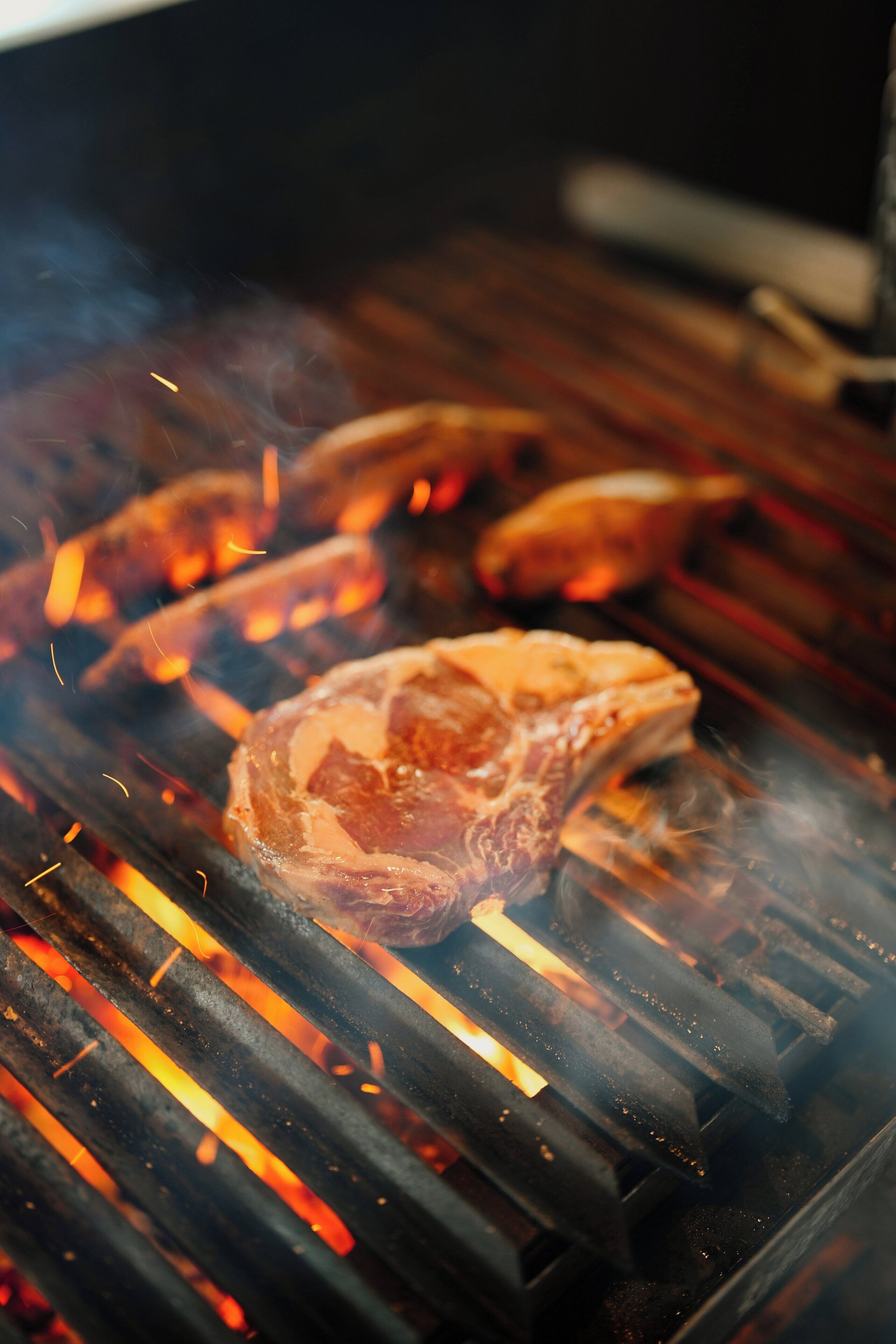 A grill with meat cooking over flames.