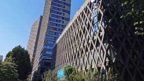 A modern building with a lattice facade and a sign indicating a hotel. - HanTing Hotel (Eye of Tianjin) (Tianjin)