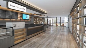 A modern coffee shop interior with a counter, seating area, and bookshelves. - HanTing Hotel (Eye of Tianjin) (Tianjin)