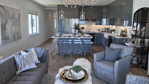 A modern kitchen with a central island, grey cabinetry, and a chandelier. - GORGEOUSLY RENOVATED! Palms C15, Gulf-Front,CORNER-UNIT, MODERN & FACING SUNSET! (Santa Rosa Beach)