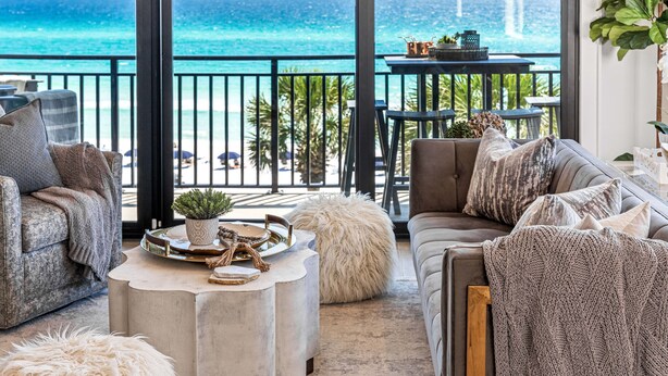 A spacious balcony with a view of the ocean, furnished with a sofa, armchairs, and a coffee table. - GORGEOUSLY RENOVATED! Palms C15, Gulf-Front,CORNER-UNIT, MODERN & FACING SUNSET! (Santa Rosa Beach)