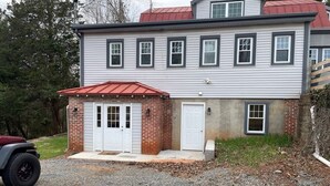 Une maison à deux étages avec un garage et un petit abri de jardin attenant.