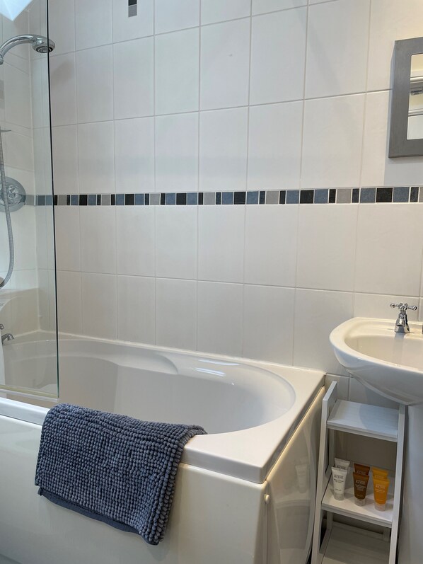 Tina con regadera, secadora de cabello, toallas, jabón