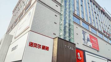 Um edifício de vários andares com diversos estabelecimentos comerciais, incluindo um KFC e um hotel.