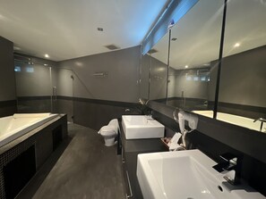 A modern bathroom with a large mirror, a bathtub, a sink, and a toilet. - Hollywood Jomtien Beach (Pattaya)