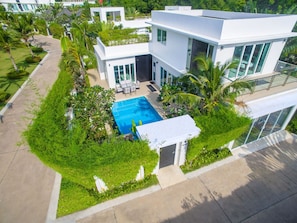 A modern two-story house with a swimming pool, surrounded by lush greenery and palm trees. - Hollywood Jomtien Beach (Pattaya)