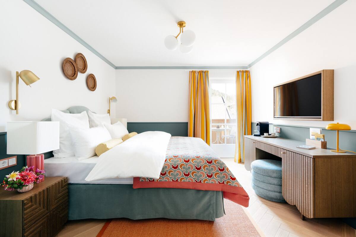 Une chambre d’hôtel moderne équipée d’un lit, d’un bureau et d’une télévision.