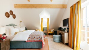 A bedroom with a bed, bedside table, lamp, and a desk with a chair. - Villa Alma - a lakeside Boutique Hotel (St. Gilgen)