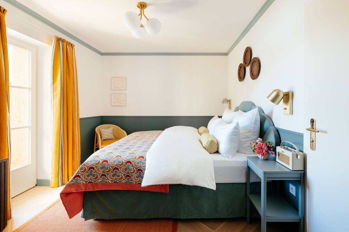 Une chambre à coucher bien rangée, avec un lit, une table de chevet et une chaise.