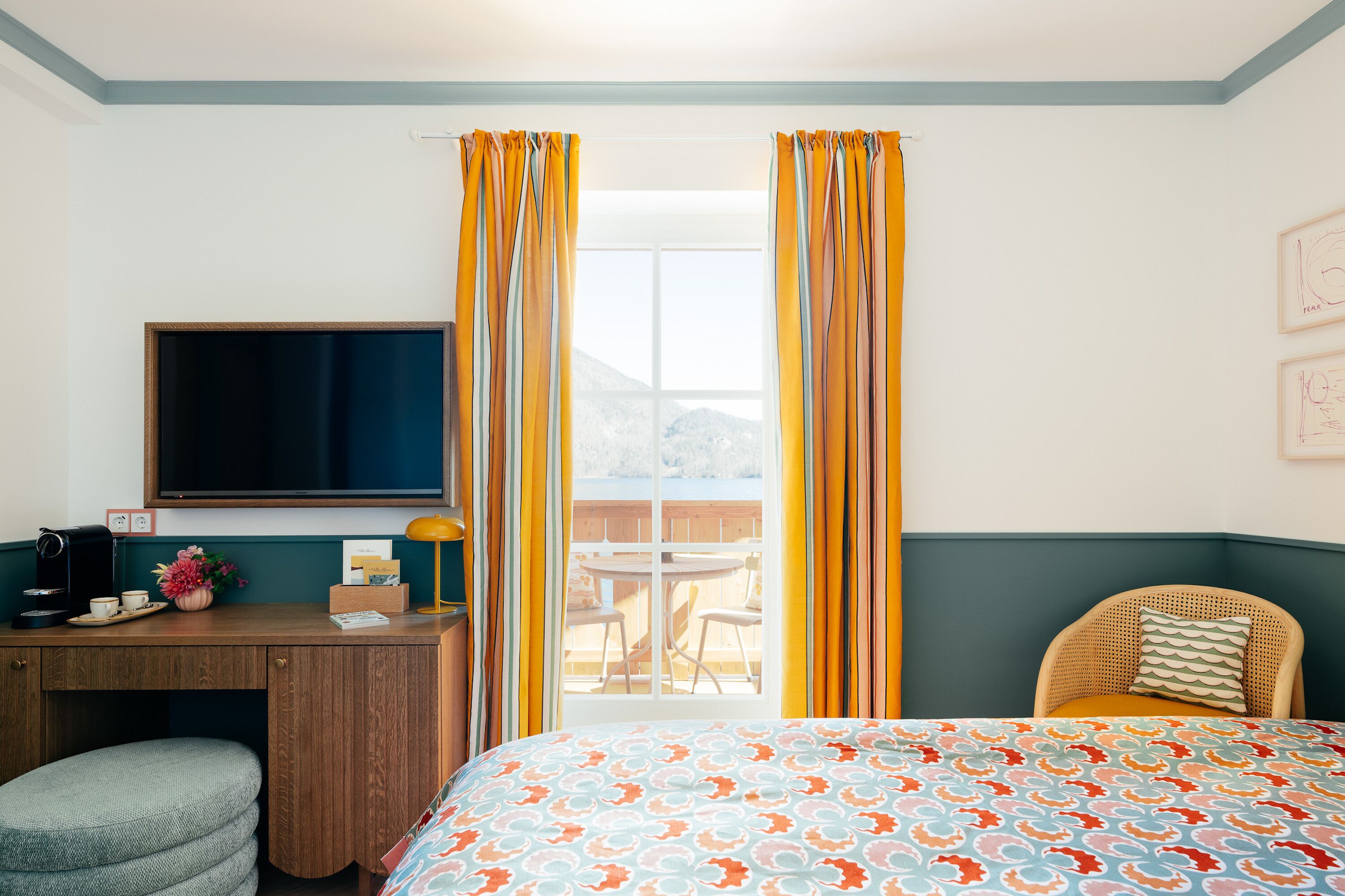 Ein Zimmer mit einem Bett, einem Schreibtisch, einem Stuhl, einem Fernseher und einem fenster mit Vorhängen.