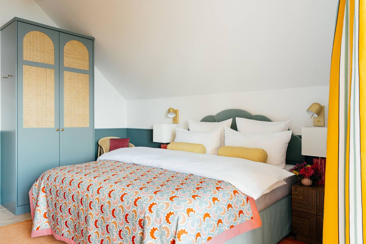 Une chambre à coucher avec un lit, une armoire et des lampes de chevet.