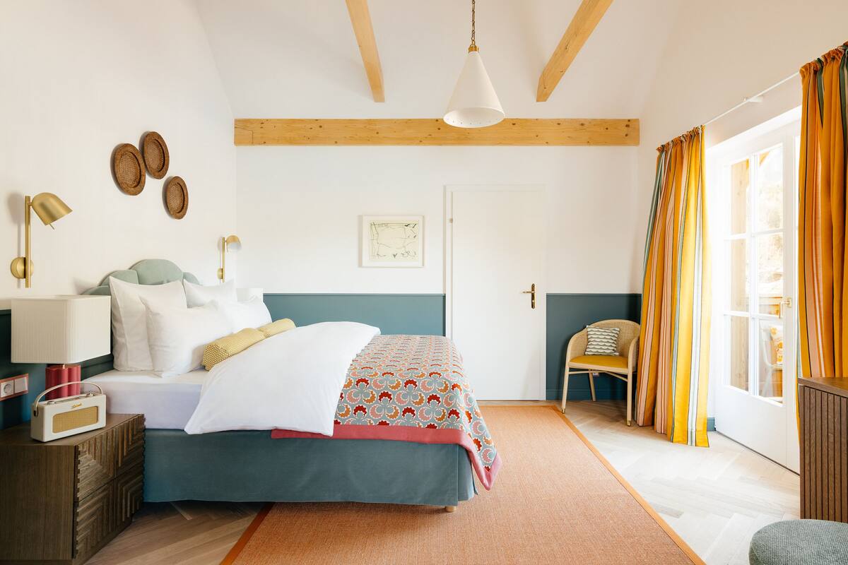 Une chambre à coucher avec un lit, une table de chevet, une lampe et une chaise.